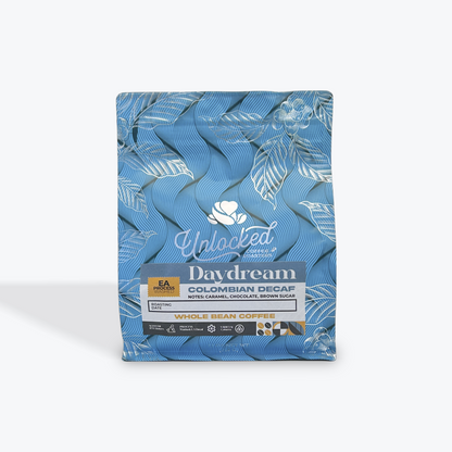 Best whole bean decaf coffee online features small batch freshness from Unlocked Coffee Roasters, with notes of caramel, chocolate, and brown sugar, packaged in a Blue airtight bag, resting on a white background, as seen at BlazeMtn.com - the best of the Carolinas. 